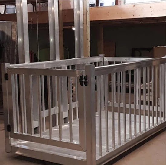 voyager HD Sturdy metal frame of a home elevator under construction, featuring vertical bars and a gate, set in a workshop.